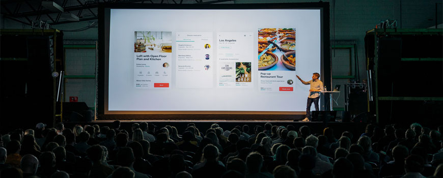 A professional presenting to a large lecture hall.